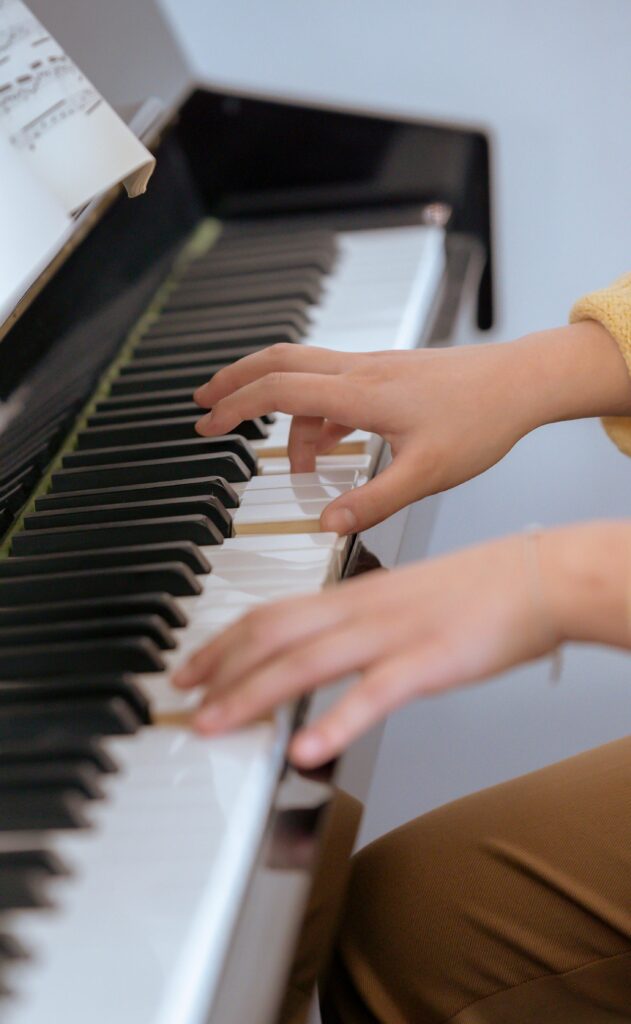 Young piano student enjoying music at the keyboard